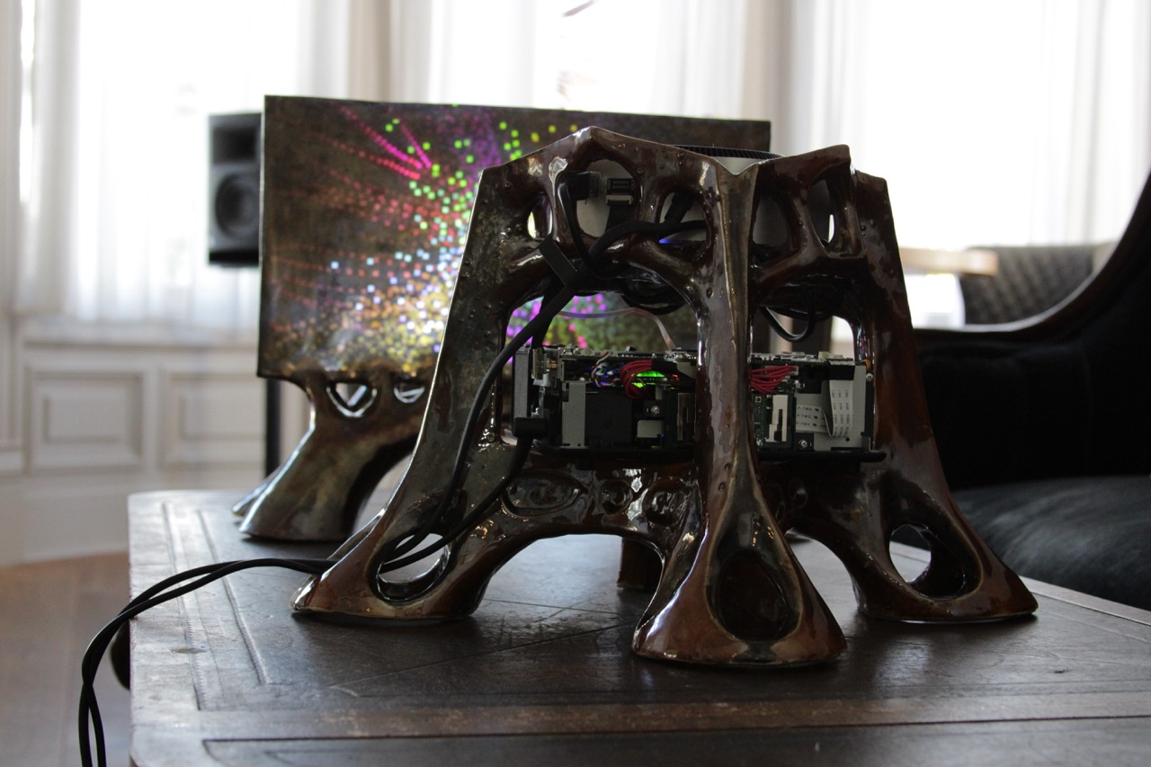 Circuit boards and cables inside the open ceramic housing, with the screen behind